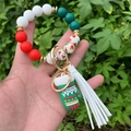 Detail of Christmas beaded keychain featuring Santa Claus charm and white leather tassel - Style 3 (Green Christmas Glove)