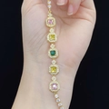 Macro detail of gold-plated bracelet with square pink and yellow stones and micro-pave crystals - Multicolor Zirconia (Gold)