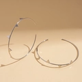 Detail of silver geometric hoop earrings with spiked rivets on a warm background - Silver Color Rivet Hoop with Silver Pin / Silver (Silver Pin)