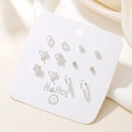 Set de 12 boucles d'oreilles argentées aux formes variées sur une carte blanche Hello - Ensemble Minimaliste Géométrique Fleur Argenté (E0030-1)