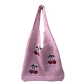 Detailopname van een roze gebreide draagtas met een leuk kersenpatroon borduursel - Roze