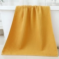 Absorbent yellow cotton waffle weave bath towel draped on white bathtub in modern bathroom - 70*140cm / Orange