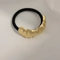 Minimalist elastic hair tie with a textured gold metal cuff and black rubber band - Arched Wave Gold