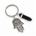 Macro shot of silver Hamsa hand charm and black crystal point pendant on key ring - Black Agate