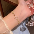 Elegant gold bracelet featuring a zircon flower charm worn on a female wrist - S755 Gold
