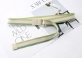 Detail of green and beige striped canvas belt with double D-ring buckle on a magazine - Green Tones Stripes