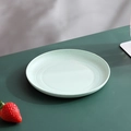 Green eco-friendly small round fruit plate with textured speckles on a green table - Green-Shallow Round Dish