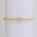 Golden beaded elastic bracelet with 18k gold cube pendant featuring a crystal letter X - Letter X