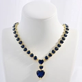Luxuriöse goldene Herzenskette mit dunkelblauen Zirkonia auf einem Halsmodell - Gold Blau Zirkonia Halskette
