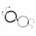 Dettaglio di bracciali magnetici per coppia con pietre laviche nere e perle bianche - Bracciale in Howlite Bianca