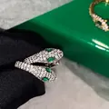 Macro shot of silver snake earrings featuring sparkling zircon micro-pave and emerald eyes - Silver Style (Silver Post)