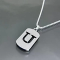 Macro view of silver titanium steel necklace featuring a hollow rectangular U letter pendant - Letter U