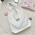 Detailed view of the 3D floral jacquard fabric on the white shoulder tote bag - White