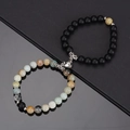 Macro detail of natural stone couple bracelets with a heart-shaped magnetic clasp - Amazon Stone And Matte Black With White Heart Magnet