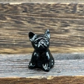 Detailed view of a small black french bulldog figurine on a natural wood surface - Obsidian