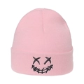 Close-up of pink knitted beanie featuring black embroidered XX face and graffiti smile - M (56-58cm) / Pink