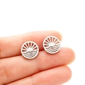 Minimalist silver geometric earrings with hollow sun and wave design held in hand - Sunrise and Wave / Steel