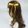 Elegant yellow polyester ribbon hair bow clip with long streamers on wavy brown hair - Yellow