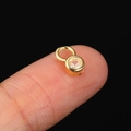 Golden round zircon charm pendant on finger showing small size for jewelry making - CC165 Round Claw / Gold