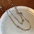 Collar de doble capa en oro con cuentas de cristal púrpura y dijes de copo de nieve - Dorado