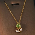 Golden tulip necklace with green cat-eye stone and crystal leaf on a jewelry card - Gold - Green Tulip