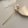 Detalle de una horquilla dorada minimalista con elegantes perlas blancas finas - F0230 Dos Perlas