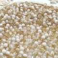 Macro shot of 10mm white and gold crackle glass beads in a white decorative tray - 8mm Semi-white Coffee