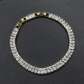 Macro del bracciale dorato con pietre di zirconia cubica bianche rettangolari su sfondo nero - Bracciale Oro