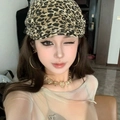 Detailed close-up of leopard print headband and large gold hoop earrings on model - White Leopard