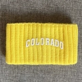 Details eines gelben gerippten Strickstirnbands mit weißem Colorado-Schriftzug - Gelb