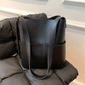 Minimalistische schwarze Leder-Eimertasche mit doppelten Fronttaschen und Riemen - Schwarz