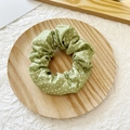 Green polka dot scrunchie on a wooden tray with a minimalist and fresh aesthetic style - Green with White Polka Dots