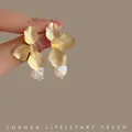 Golden flower petal earrings with baroque pearl drop in elegant hand-held showcase - Petal Pearl Drop Earrings