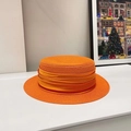 Detail of a bright orange flat-top straw hat featuring a pleated satin ribbon decoration - Orange/Same Color Ribbon