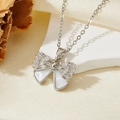 Détail du collier noeud argenté avec cristaux baguette et incrustation nacre - Style Nœud Coquille Blanche Argent (T015)