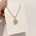 Dettaglio del ciondolo Occhio del Male dorato con catena paperclip su carta bianca - DN065 Occhio Cavo Rotondo / Oro
