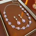 Détail du collier et des boucles d'oreilles avec cristaux violets en poire sur plateau marron - Ensemble 2 pièces - Violet / Violet