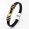 Close-up of black braided leather bracelet with gold hollow metal charm and silver buckle - Saxophone