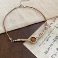 Detail view of amber resin pendant with wooden beads on ethnic geometric necklace - Necklace-Coffee-Oval