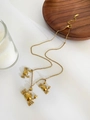 Dettaglio di tre ciondoli a forma di granchio dorato su una collana minimalista - Piccolo Granchio d'Oro
