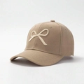 Close-up of 3D embroidered white bow on a khaki cotton baseball cap with twill texture - One Size / Khaki