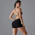 Dettaglio del reggiseno sportivo incrociato e pantaloncini a vita alta push up neri - S / Nero