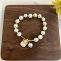 Macro detail of Baroque freshwater pearl bracelet with a golden lucky cat charm on wood - 25# Lucky Fortune Cat White Pearl Bracelet