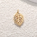 Macro view of a gold leaf pendant with hollow design and clear cubic zirconia stones - Gold Mini Leaf