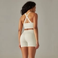 Detail view of seamless light beige yoga set showing crisscross back straps and high waist shorts - S / Top And Bottom / Cross Bra + Shorts / Off White