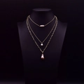 Collier à trois rangs doré avec perles baroques sur buste de bijoux noir - Collier à pendentif triple rang en perles baroques