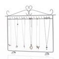 White iron wall-mounted necklace display stand with heart scrollwork and 20 hooks - White