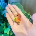 Orange seahorse hair clip made of translucent resin shown held in hand outdoors - Seahorse