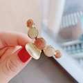 Detailed close-up of a golden alloy hair claw clip with pink and white enamel beads - Milk Orange-White Marble