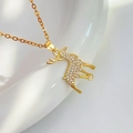 Dettaglio macro di una collana con ciondolo a forma di alce dorata e zirconi scintillanti - Cerbiatto Oro